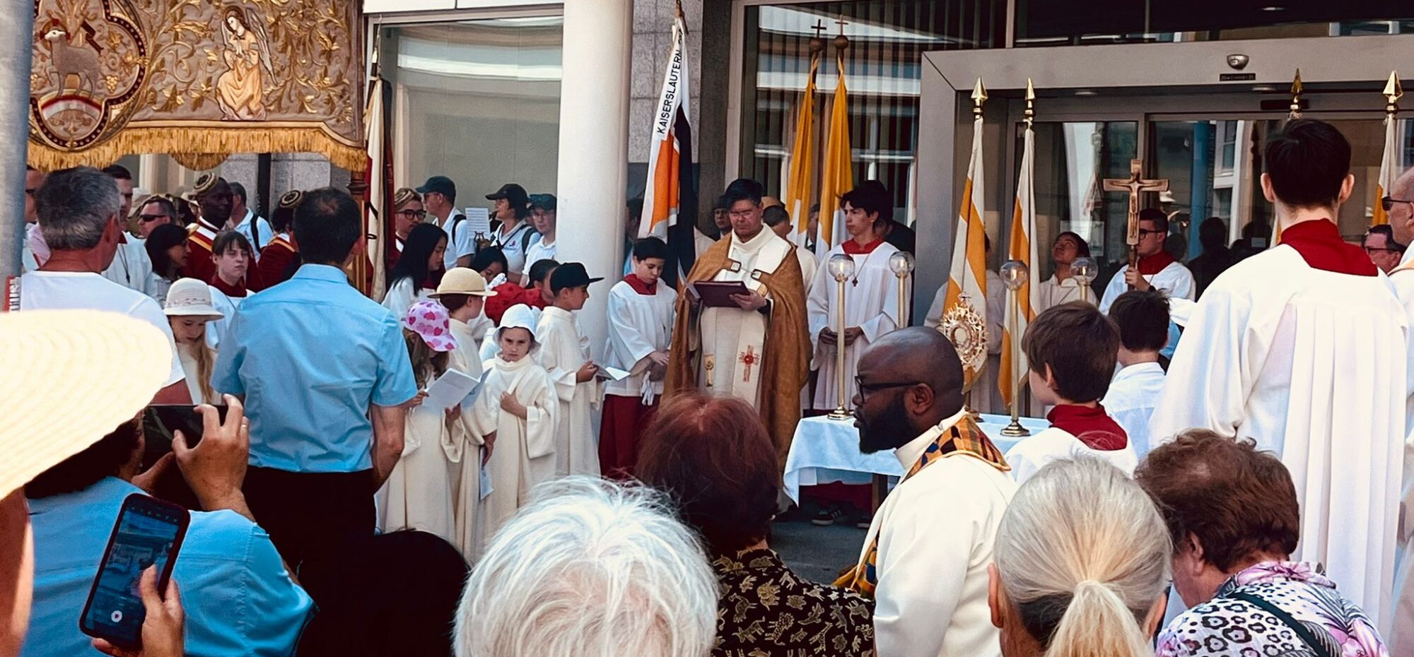 Das Foto zeigt Priester, Ministranten, Gläubige - viele Menschen feiern in Kaiserslautern das Fronleichnamsfest.